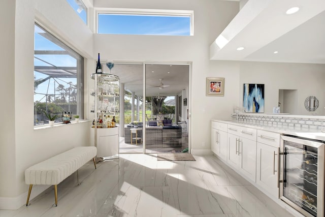 bathroom featuring decorative backsplash, ceiling fan, and wine cooler