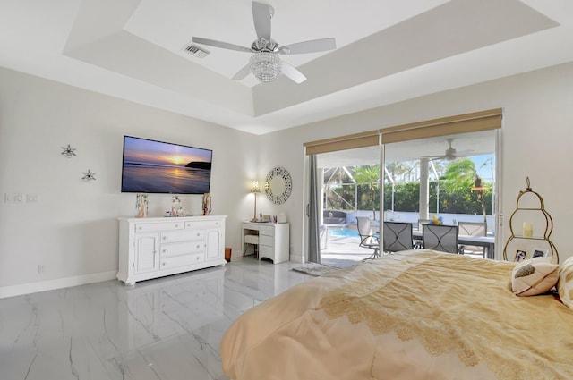 bedroom with a raised ceiling, access to exterior, and ceiling fan