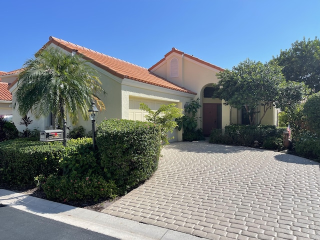 mediterranean / spanish-style home with a garage