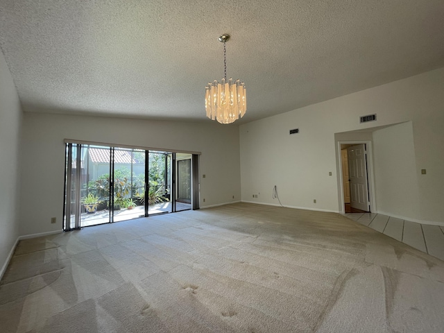 unfurnished room featuring a textured ceiling, light carpet, and an inviting chandelier