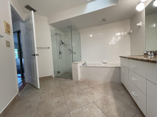 bathroom with tile patterned flooring, vanity, and shower with separate bathtub