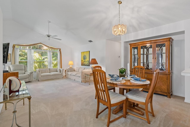 carpeted dining room with vaulted ceiling and ceiling fan with notable chandelier