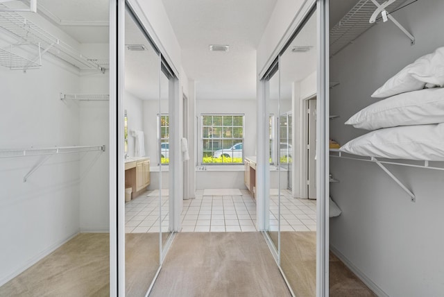 walk in closet featuring light colored carpet