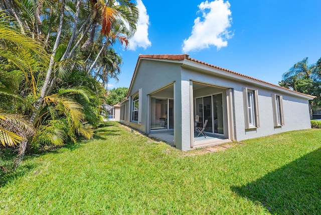 rear view of property with a lawn