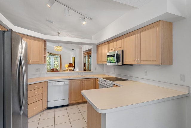 kitchen with kitchen peninsula, appliances with stainless steel finishes, decorative light fixtures, and light brown cabinetry