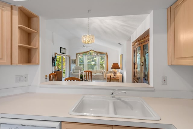 kitchen featuring dishwashing machine, sink, light brown cabinets, pendant lighting, and a chandelier