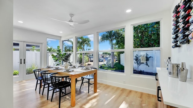 dining room featuring ceiling fan, plenty of natural light, light hardwood / wood-style flooring, and french doors