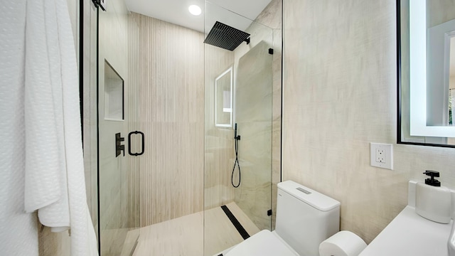 bathroom with toilet and a shower with door