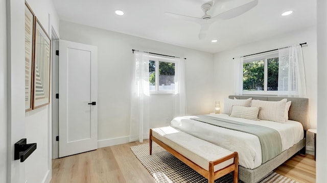 bedroom featuring ceiling fan, light wood-type flooring, and multiple windows