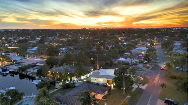 aerial view at dusk featuring a water view