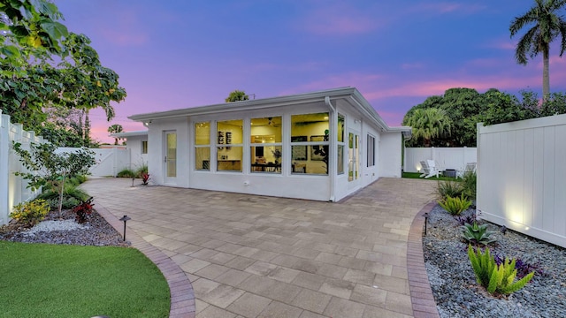 back house at dusk with a patio