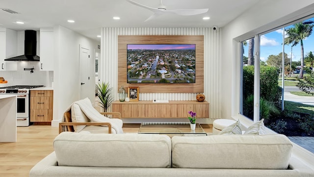 living room featuring light hardwood / wood-style flooring and ceiling fan