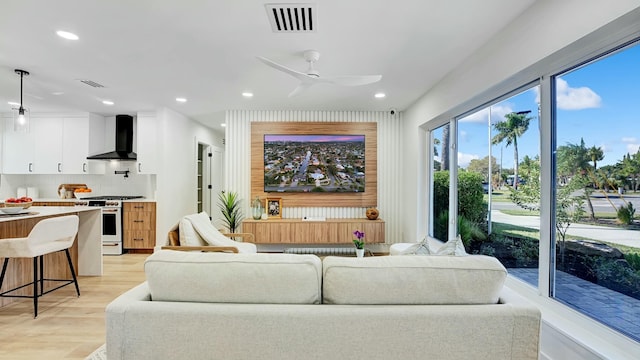 living room with ceiling fan and light wood-type flooring