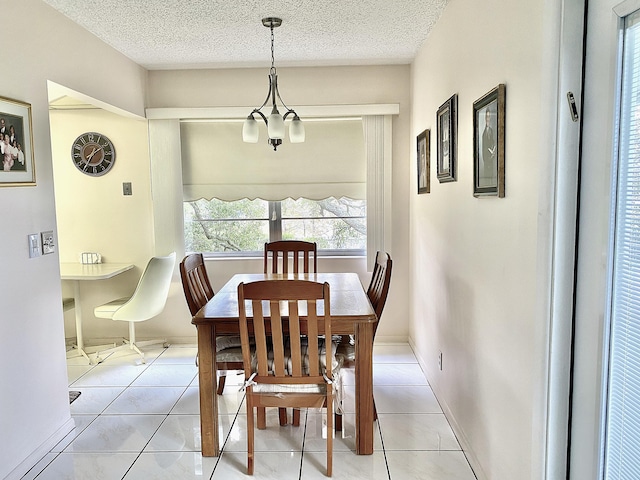 tiled dining space featuring a notable chandelier and a textured ceiling