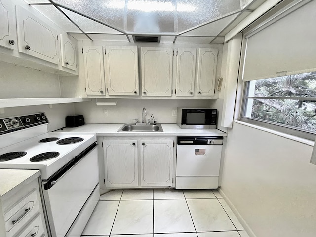 kitchen with white cabinetry, sink, light tile patterned floors, and white appliances