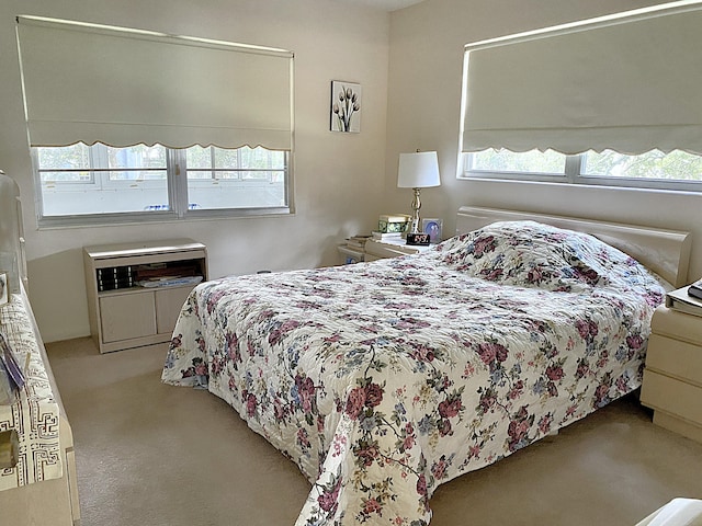 bedroom with light colored carpet and multiple windows