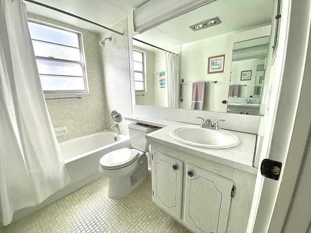 full bathroom featuring vanity, shower / bath combo, toilet, and a wealth of natural light