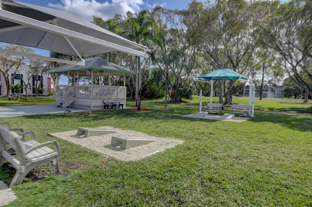 view of community featuring a gazebo, a wooden deck, and a lawn