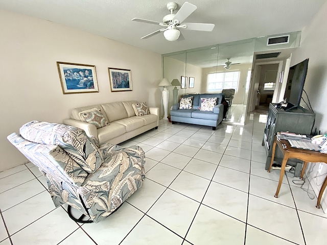 living room with tile patterned floors, ceiling fan, and a textured ceiling