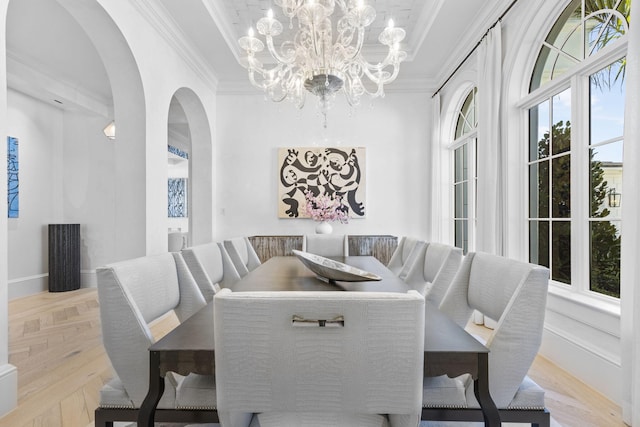 dining space featuring a chandelier, crown molding, and light parquet floors