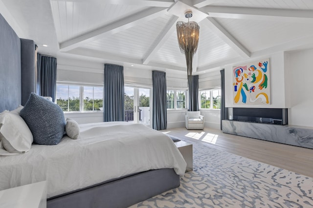 bedroom with a notable chandelier, beam ceiling, wood-type flooring, and multiple windows