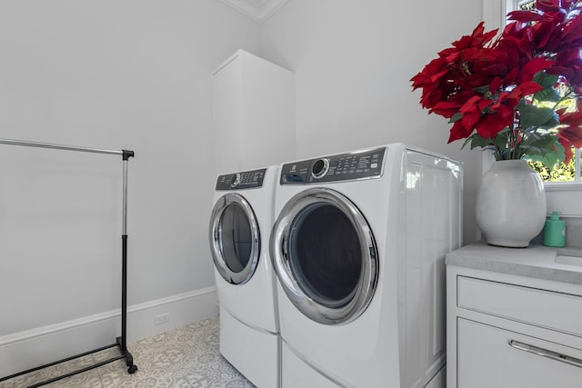 washroom with washer and dryer, light tile patterned floors, and crown molding