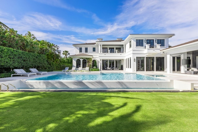 back of house with a lawn and a patio