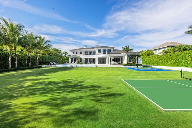 rear view of house with tennis court and a patio area