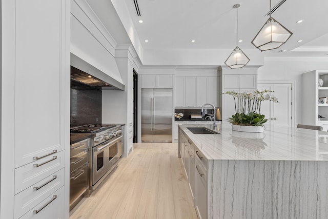 kitchen featuring a large island, high quality appliances, white cabinetry, and sink