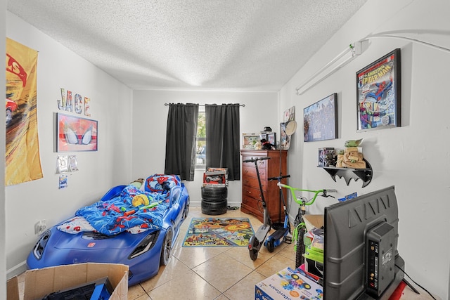 bedroom featuring light tile patterned floors and a textured ceiling