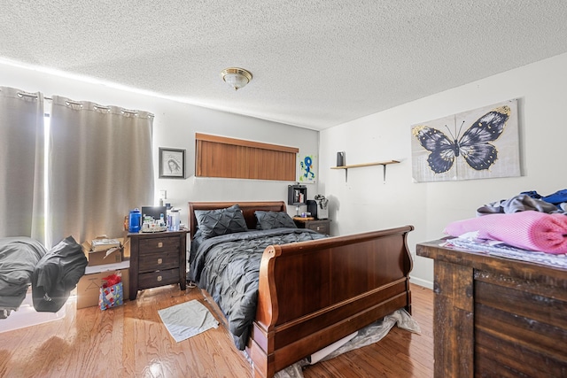 bedroom featuring a textured ceiling and light hardwood / wood-style floors