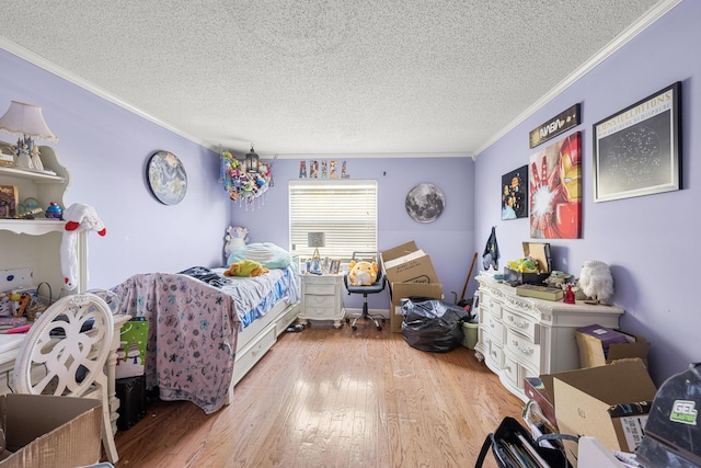 bedroom featuring light hardwood / wood-style flooring, a textured ceiling, and ornamental molding