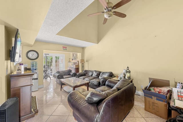 living room with ceiling fan, french doors, light tile patterned floors, and a textured ceiling