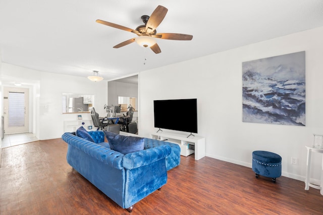 living room with ceiling fan and dark wood-type flooring