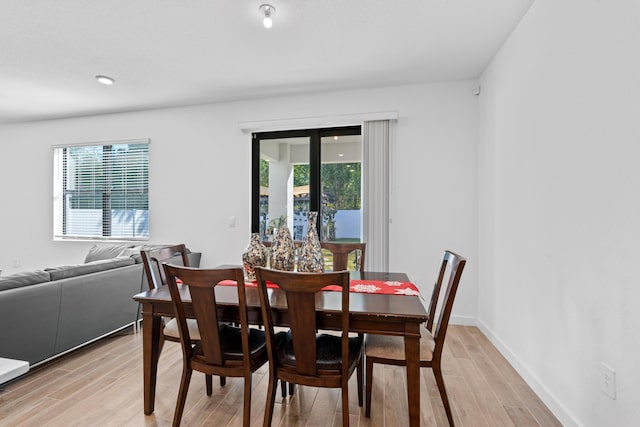 dining room with light wood-type flooring and a wealth of natural light