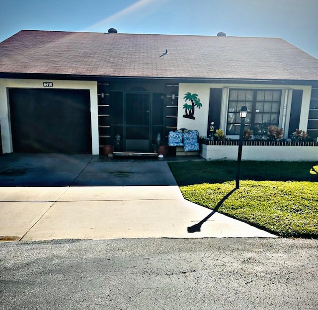 view of front of home with a front yard and a garage