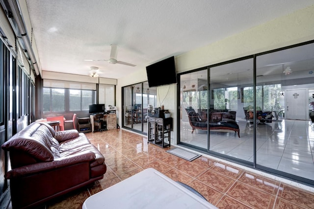 tiled living room with ceiling fan and a textured ceiling