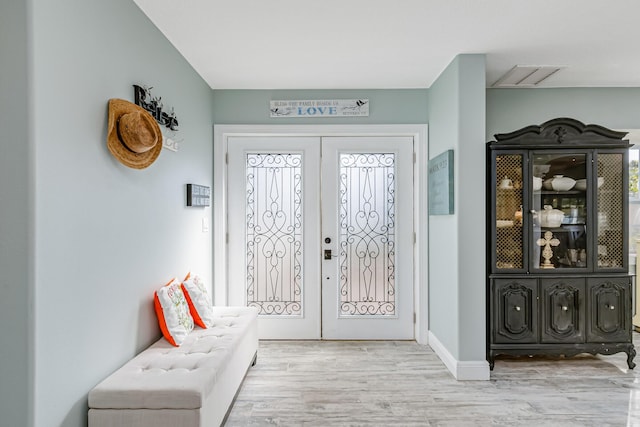 entrance foyer with french doors and light hardwood / wood-style flooring