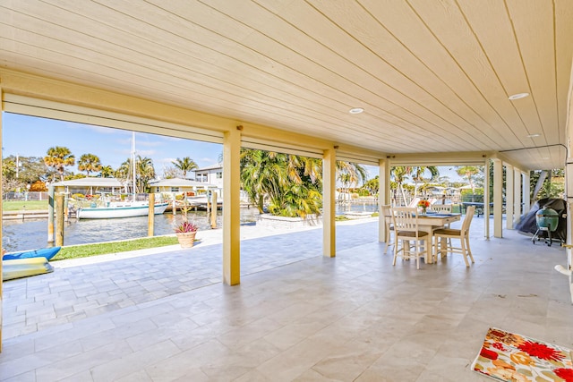 view of patio featuring a water view and a boat dock