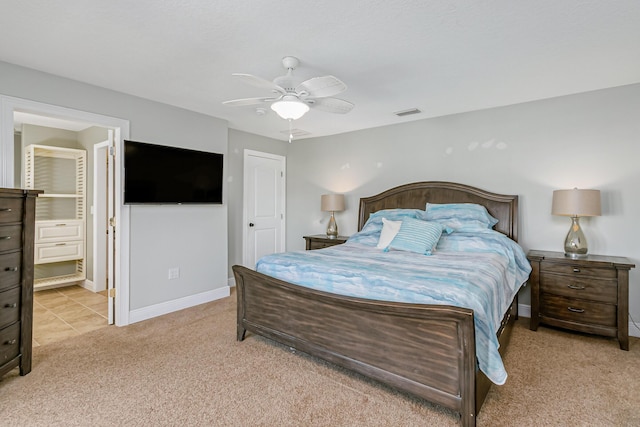 carpeted bedroom featuring ceiling fan and ensuite bathroom