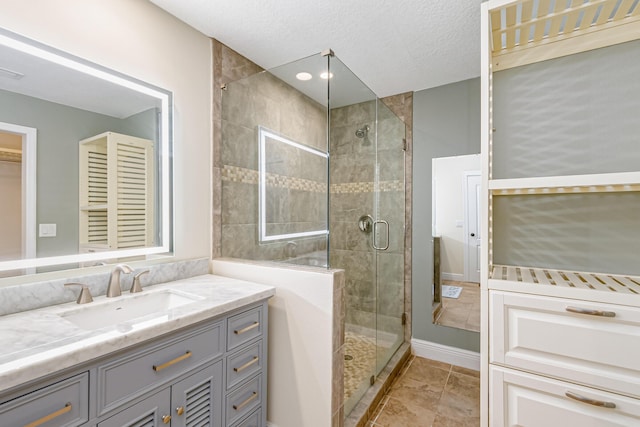 bathroom with vanity, tile patterned flooring, a textured ceiling, and walk in shower