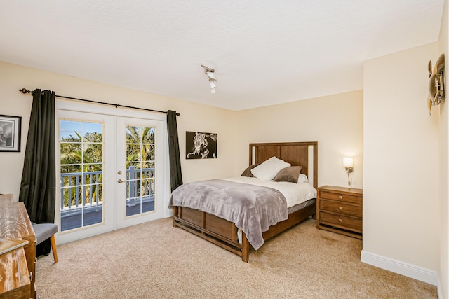 bedroom with light colored carpet, french doors, and access to exterior