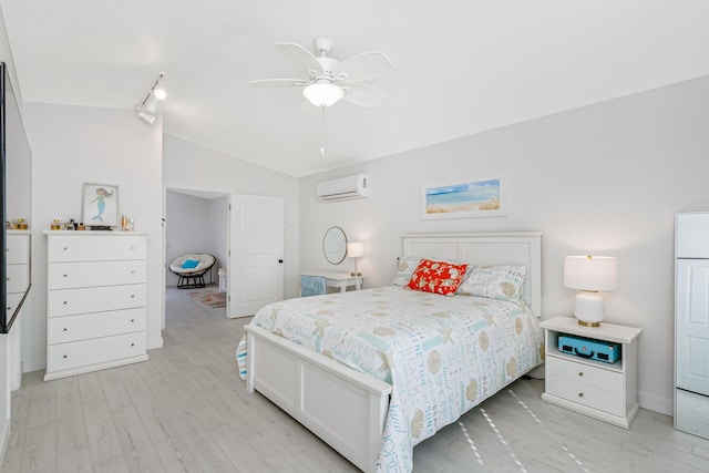 bedroom featuring a wall unit AC, ceiling fan, track lighting, vaulted ceiling, and light hardwood / wood-style flooring