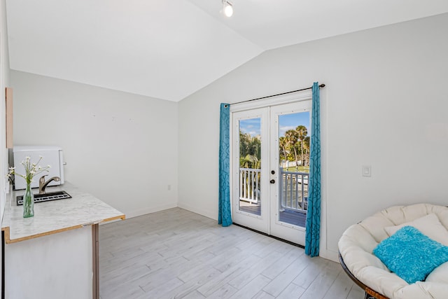 entryway with light hardwood / wood-style floors, sink, french doors, and vaulted ceiling