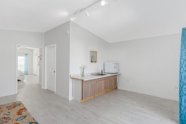 kitchen featuring light wood-type flooring, rail lighting, and lofted ceiling