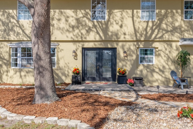 property entrance with a patio area and french doors