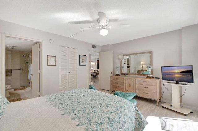 bedroom featuring connected bathroom, a closet, light hardwood / wood-style flooring, and ceiling fan