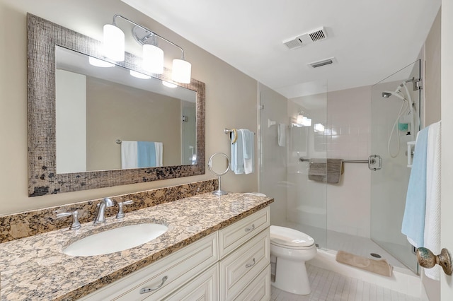 bathroom with tile patterned floors, vanity, toilet, and a shower with door