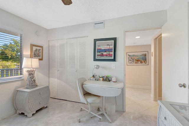 interior space with a textured ceiling and tile patterned floors