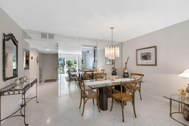 tiled dining room featuring a notable chandelier